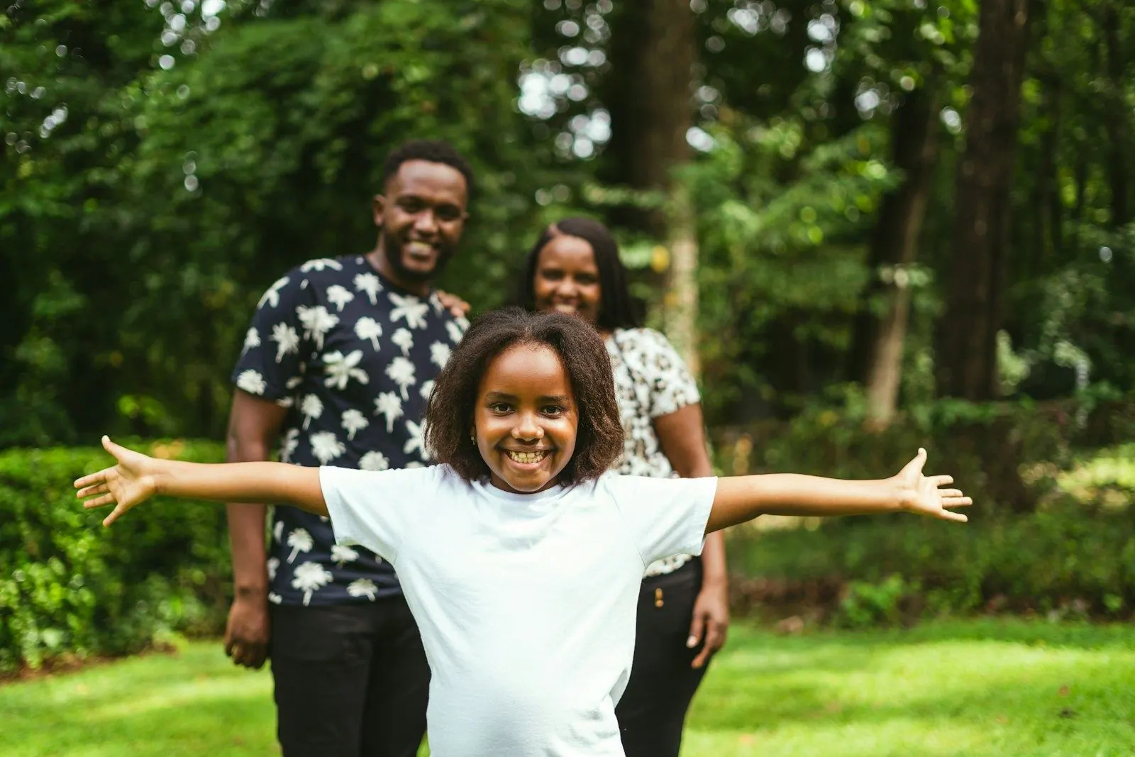 Family relocation to Spain: parents and their smiling daughter in a park