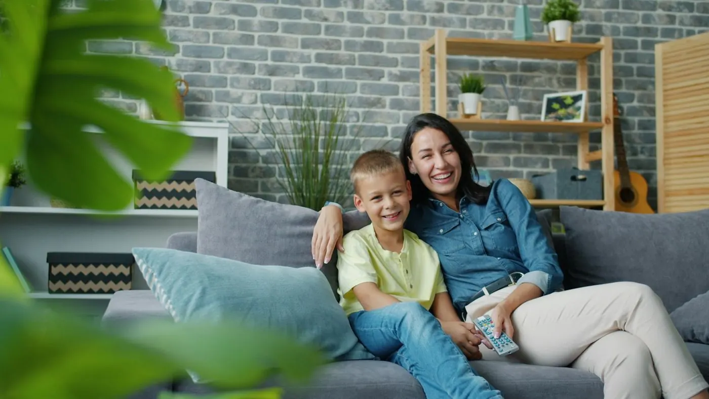 Mother and son laughing on the sofa at home