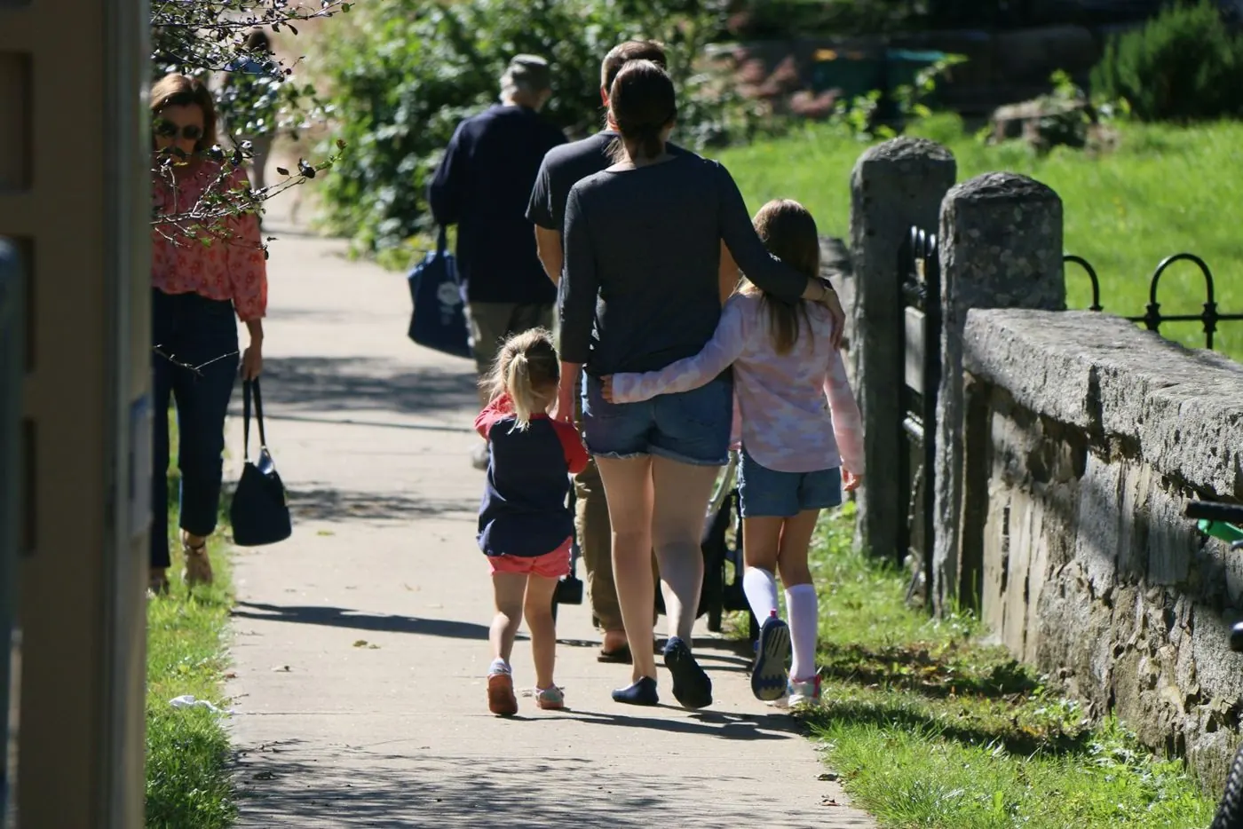 Family walking along a leafy path