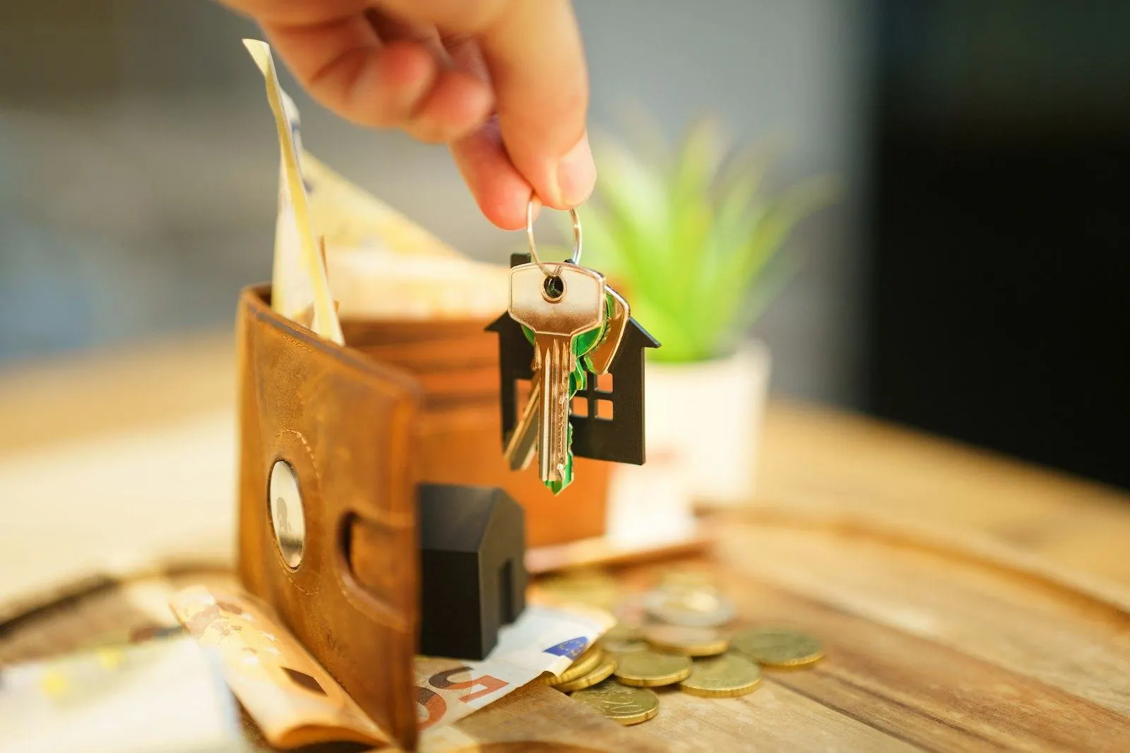 Keys to a new home held over a wallet