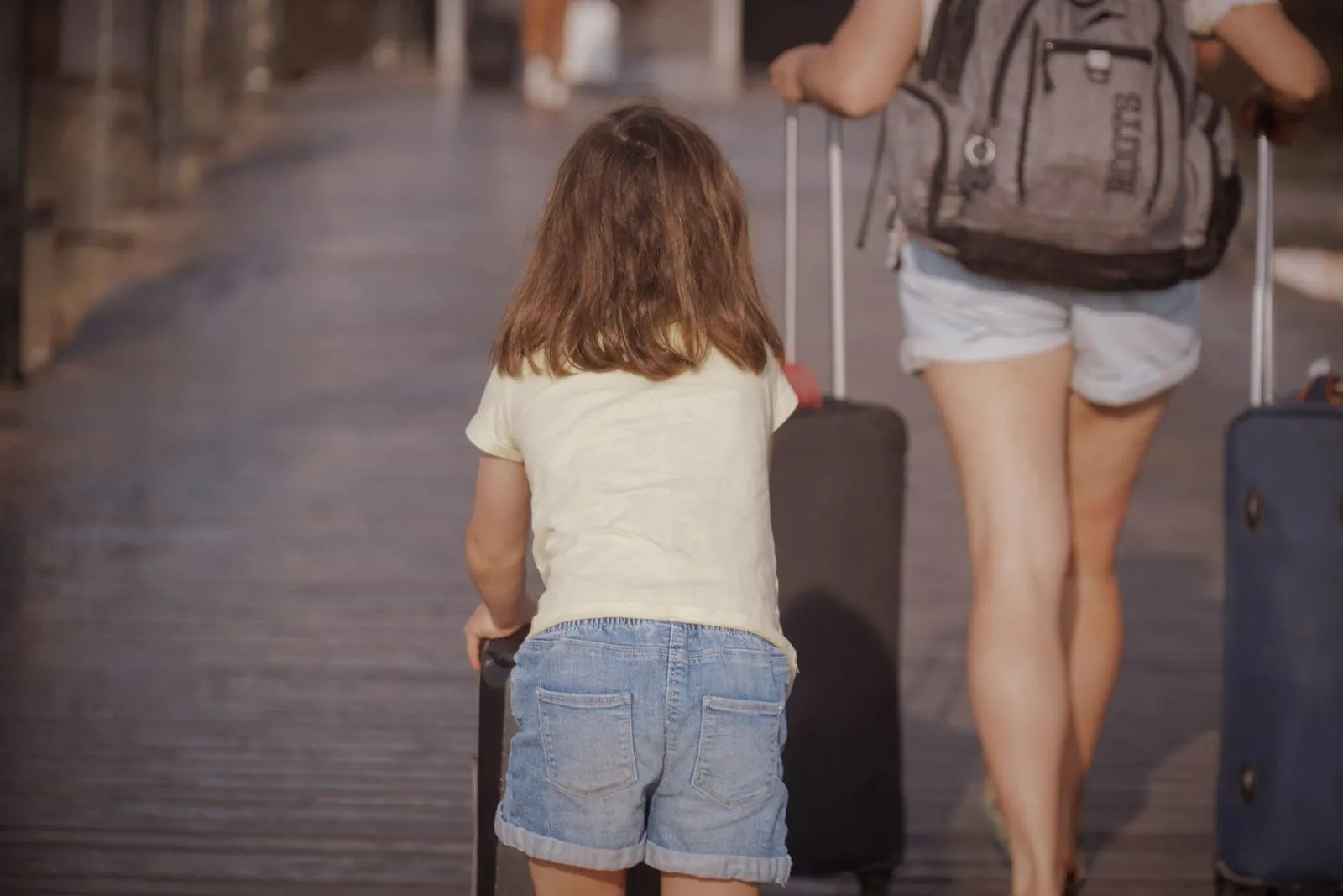 Mother and daughter pulling their suitcases