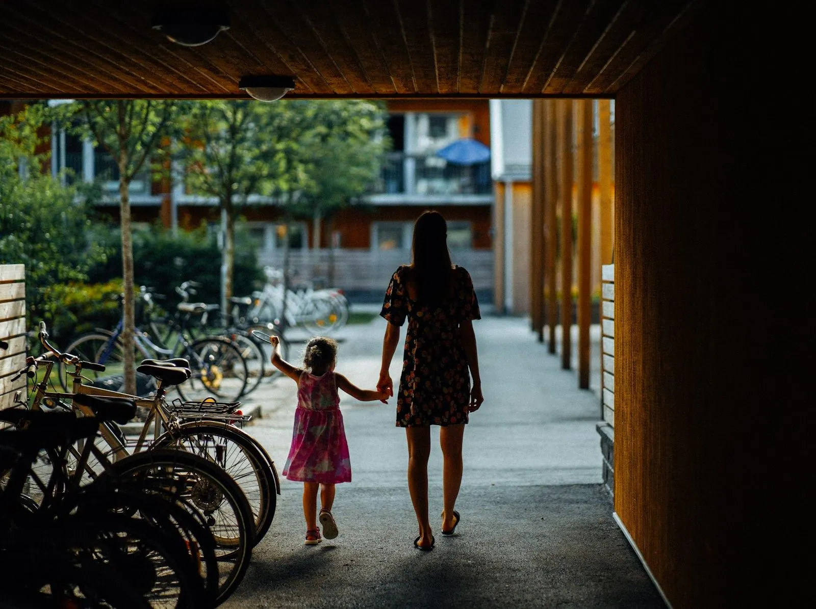 Mother and daughter walking hand in hand into their new neighbourhood